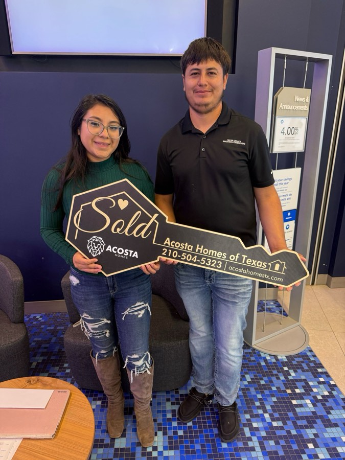 A young Acosta couple holding the Sold key at closing